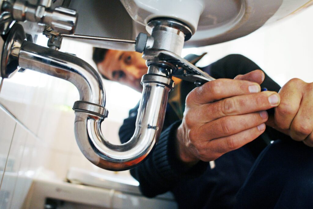 close up of plumber repairing sink plumber-repairing-sink