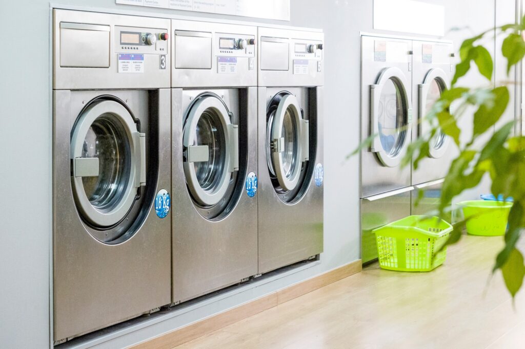 commercial laundry equipment 1 Public laundry with modern, silver washing machines in a row
