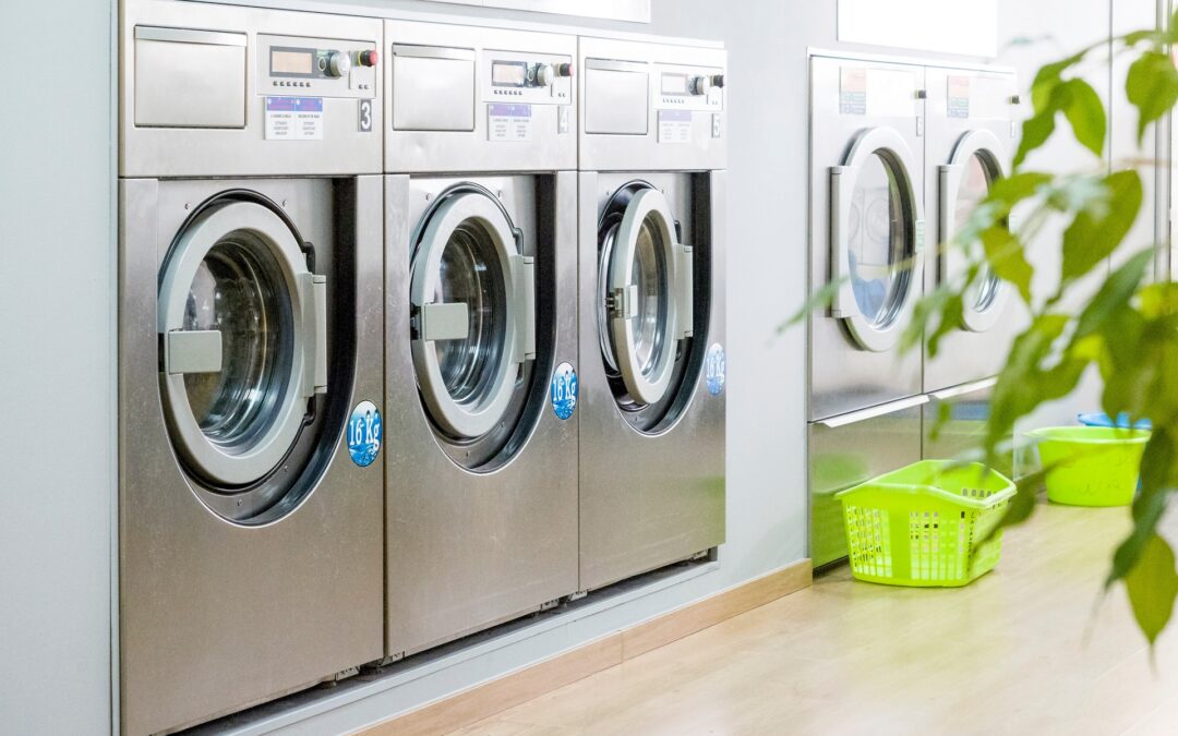Public laundry with modern, silver washing machines in a row