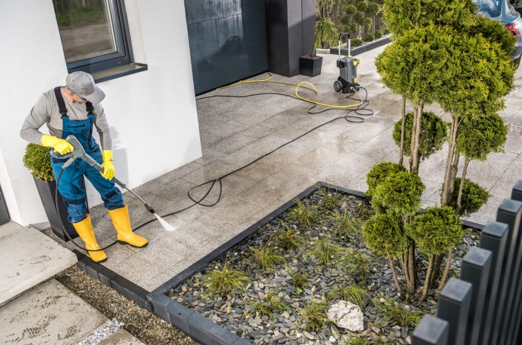 Man Pressure washing a walkway